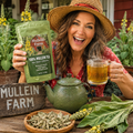 A woman in a straw hat holds up a green bag of Mullein Farm 100% Mullein Tea next to a green teapot and a glass mug of tea on a rustic wooden table, with fresh herbs and flowers in the background.